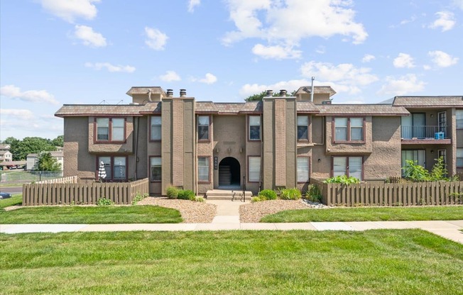 A row of houses with a green lawn in front.