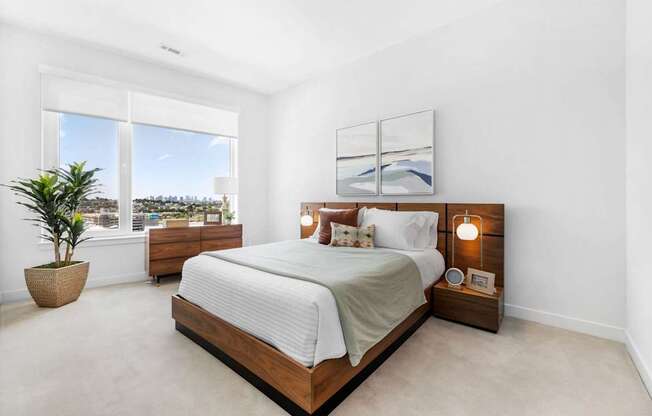 A bedroom with a large bed and a potted plant.
