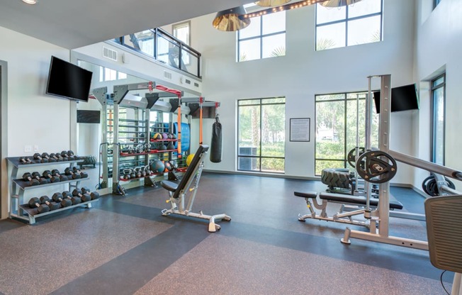 a gym with weights and other equipment and windows