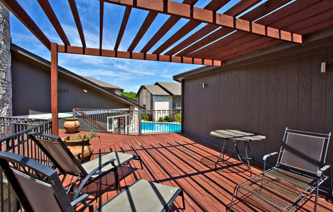 a covered deck with a pool and patio furniture