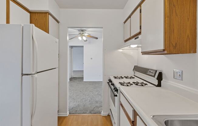 a kitchen with white countertops and a white refrigerator