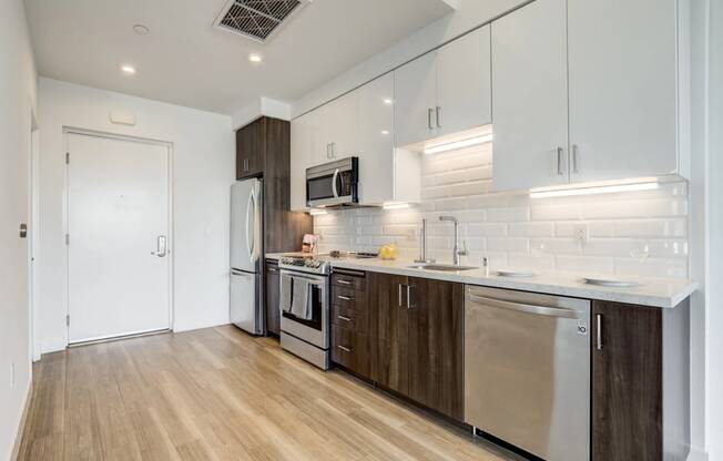 a modern kitchen with stainless steel appliances and white cabinets