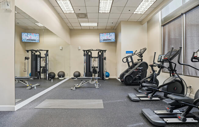 A gym with treadmills, exercise bikes, and weightlifting equipment.