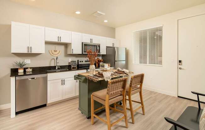 A kitchen with a table and chairs in the middle.