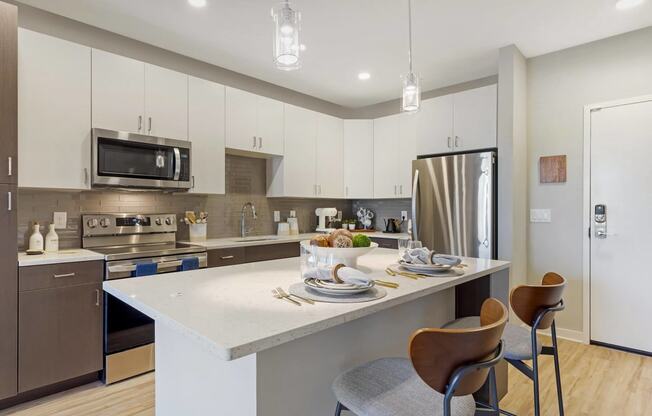 a kitchen with white cabinets and a large island with a white countertop