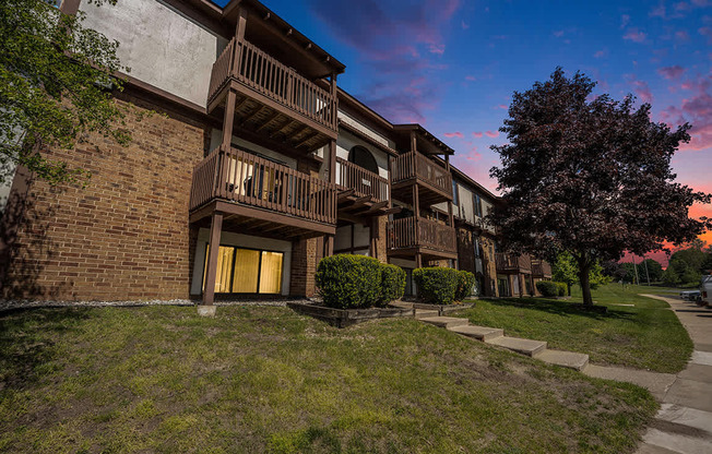 A building with balconies and a tree in front at Seville Apartments, Michigan