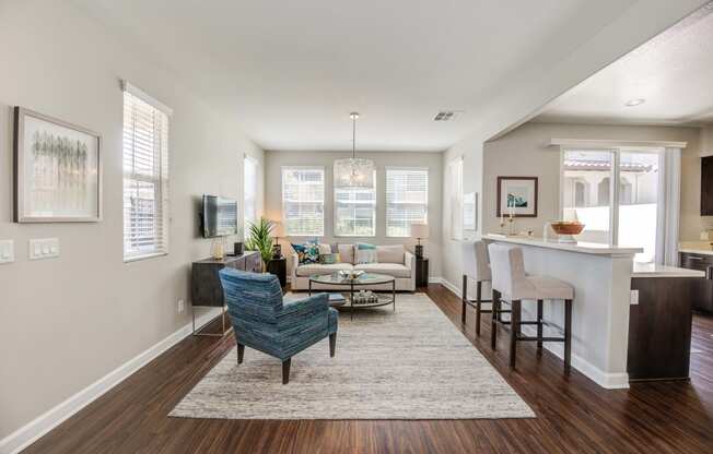 an open living room and kitchen with a bar and a living room with couches