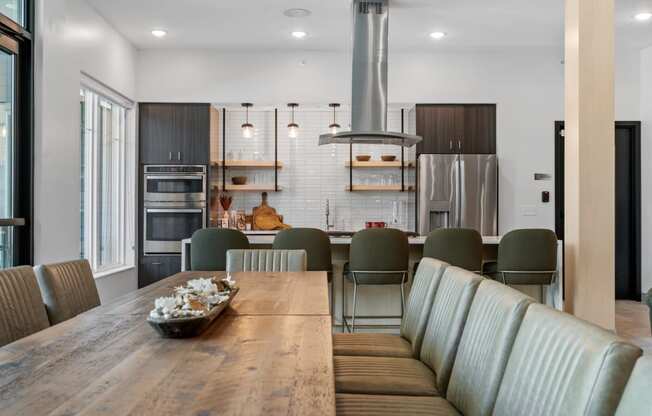 a kitchen and dining area with a wooden table and grey chairs at The Lodge at Overland, Minnesota, 55901