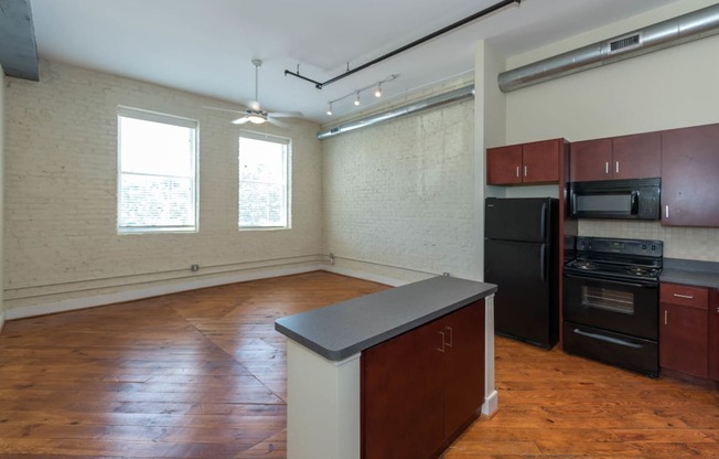 an empty kitchen with an island in the middle of it at Mayton Transfer Lofts, Petersburg Virginia