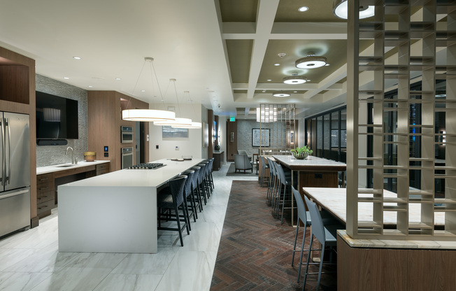 Alternate view of the clubhouse space showing the large HDTV mounted in the catering kitchen and the white marble floors.