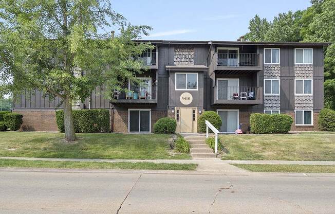 a large apartment building with a tree in front of it