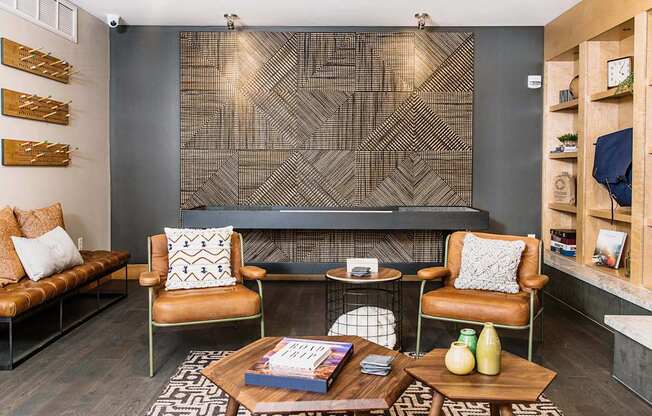 Cozy communal lounge in the apartment complex featuring stylish seating arrangements, a modern flat-screen TV, a warm fireplace, and a tabletop shuffleboard for residents to enjoy.