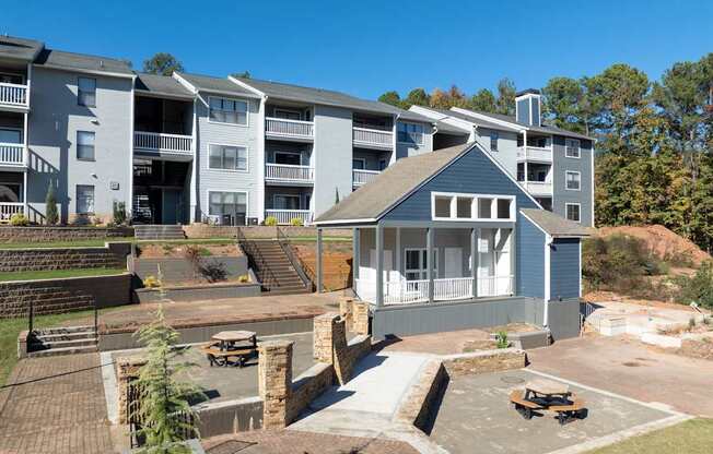 A large apartment complex with a small house in the foreground.