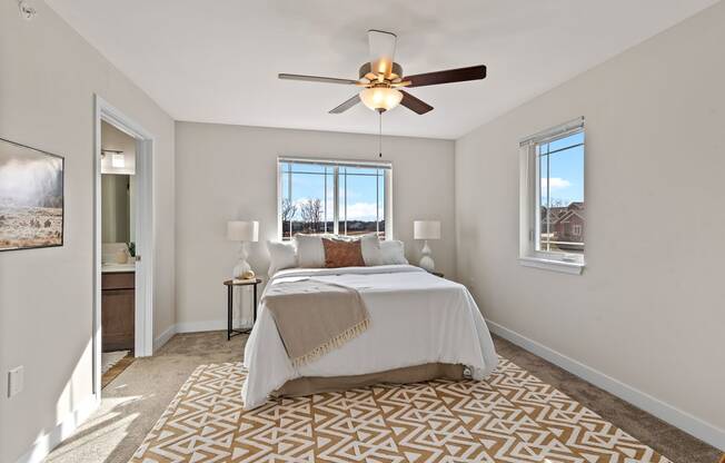 a bedroom with a bed and a ceiling fan at The Residences Apartments at Bear Tree | DeForest, WI, DeForest Wisconsin