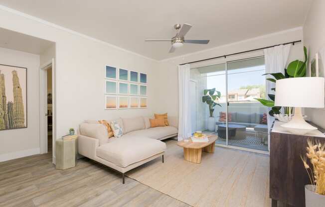 a living room with a white couch and a sliding glass door