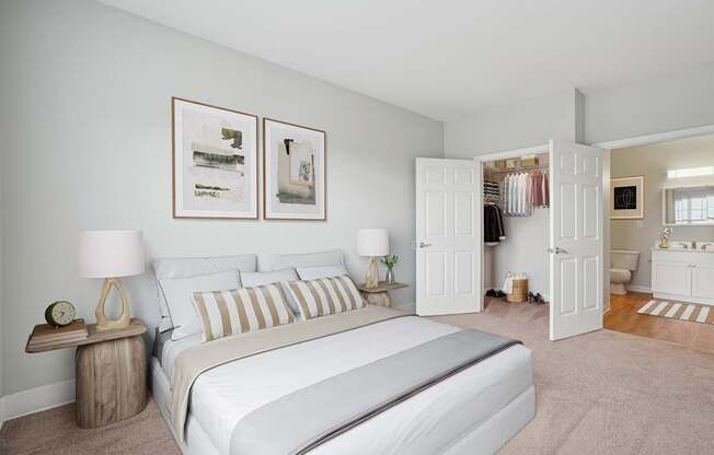 A bedroom with a large bed and two lamps.