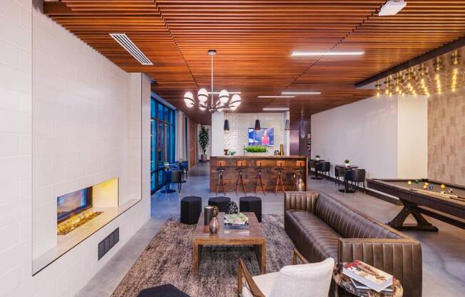 A modern living room with a pool table and a fireplace.