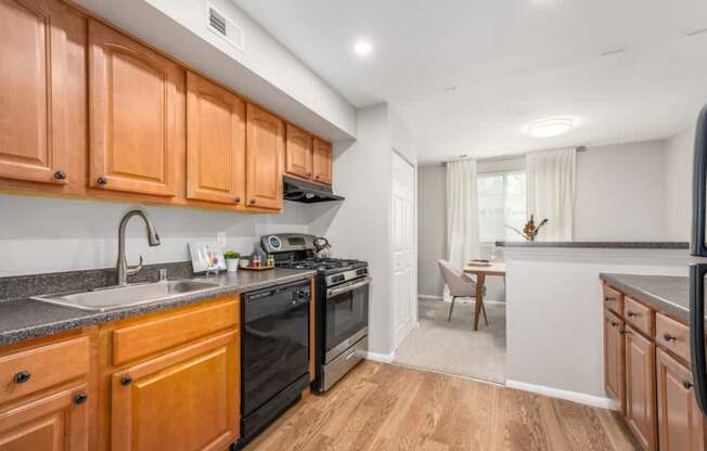 A kitchen with wooden cabinets and black appliances.