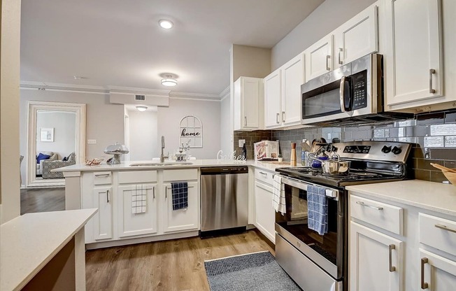 a kitchen with white cabinets and stainless steel appliances