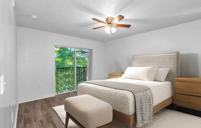 A bedroom with a bed, a chair, and a window.