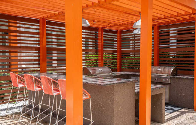 A patio with orange pillars and a table with chairs.