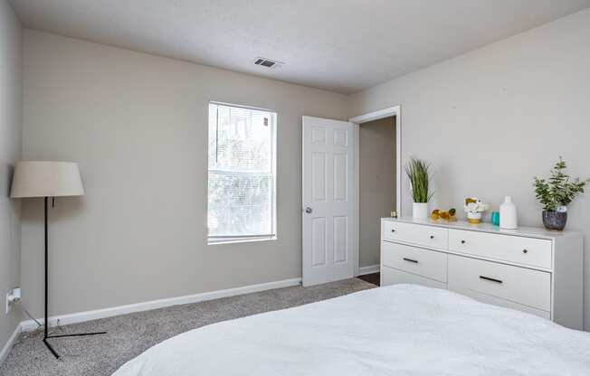 a bedroom with white cabinets and a white bed