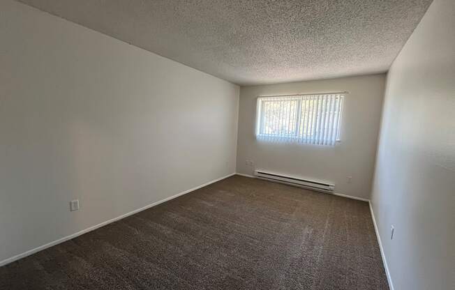 an empty bedroom with a window