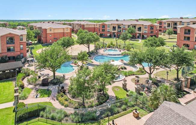 A large outdoor swimming pool surrounded by a grassy area and trees.