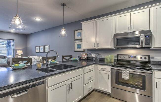 Large open floor plan kitchen with white cabinetry and stainless steel appliances