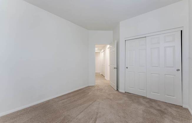 A room with a carpeted floor and a white door.