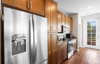 a kitchen with wooden cabinets and stainless steel appliances