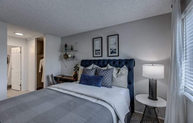 a bedroom with a bed and a nightstand with a lamp