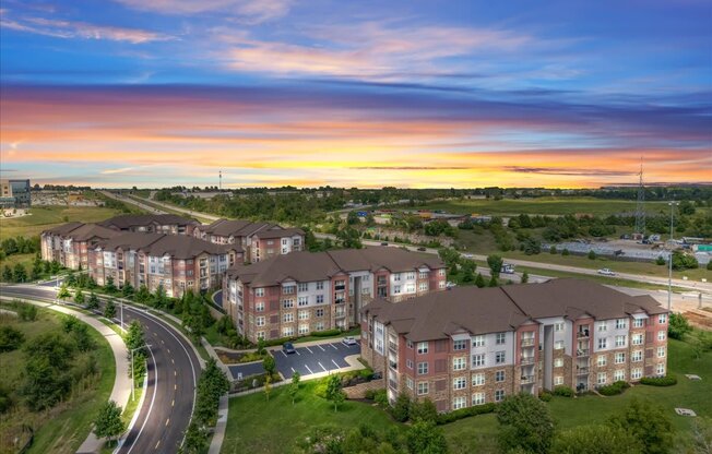 A large apartment complex with a curved road in front of it.