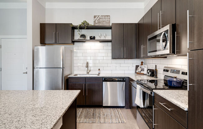 a kitchen with stainless steel appliances and marble counter tops