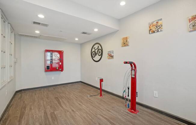 A room with a red piece of equipment and a clock on the wall.