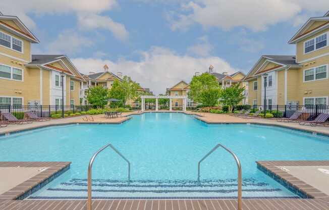 large swimming pool with handrails and stairs at Fenwyck Manor Apartments