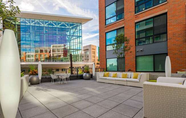 A modern outdoor seating area with white furniture and a large white sculpture.