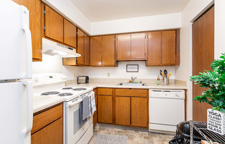 A kitchen with wooden cabinets and white appliances.