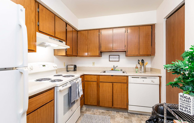 A kitchen with wooden cabinets and white appliances.