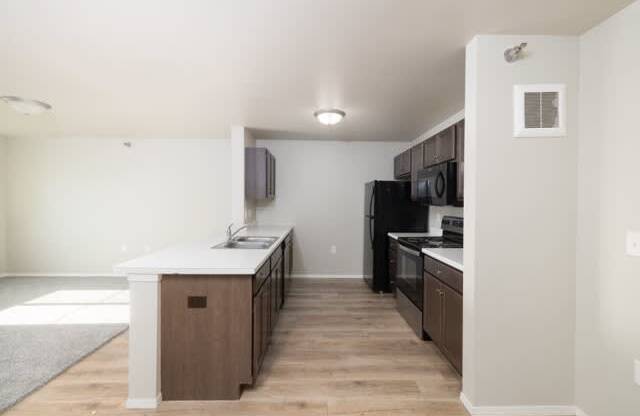 A kitchen with a white counter top and wooden cabinets.