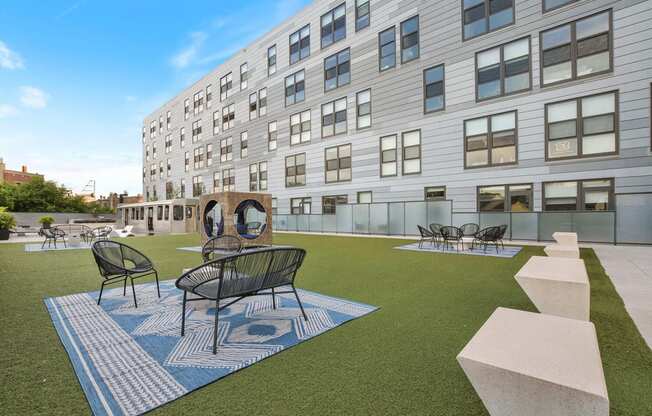 a courtyard with tables and chairs in front of a building