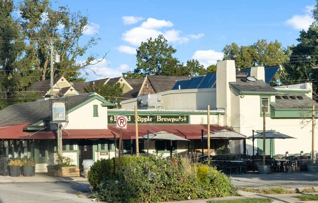 a restaurant with tables and umbrellas in front of a building