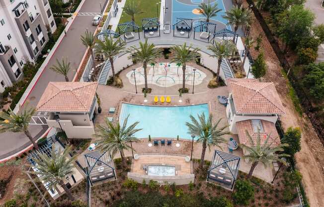 A pool surrounded by palm trees and a playground.