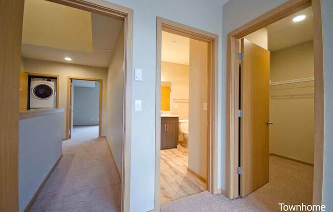 A hallway with a washer and dryer in a home at Spyglass Hill Apartments, Bremerton
