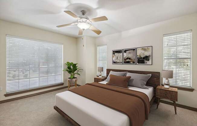 A bedroom with a bed, a ceiling fan, and a potted plant.