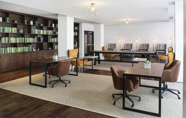 A room with a long table and chairs, a bookshelf, and a couch.
