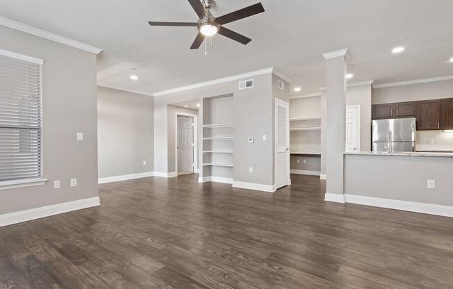 a living room with a ceiling fan and a kitchen in the background at The Verandah, Austin, 78726