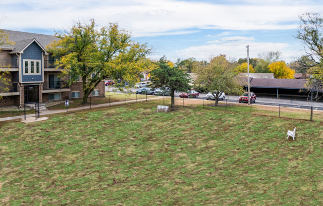 A grassy field with a white chair in the middle.