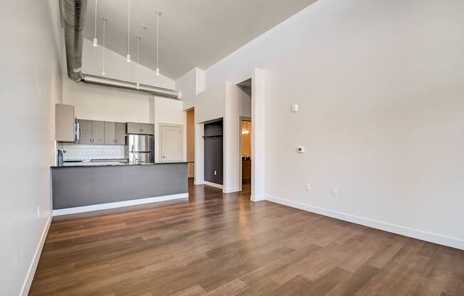 a bedroom with a medium sized bed and a kitchen in the background