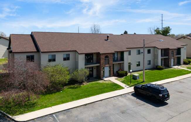 a large apartment building with a black car parked in front